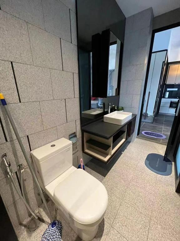 a bathroom with a white toilet and a sink at Borderless Swimming Pool - Invincible Twin Towers View - Free WiFi in Kampong Gombak Utara