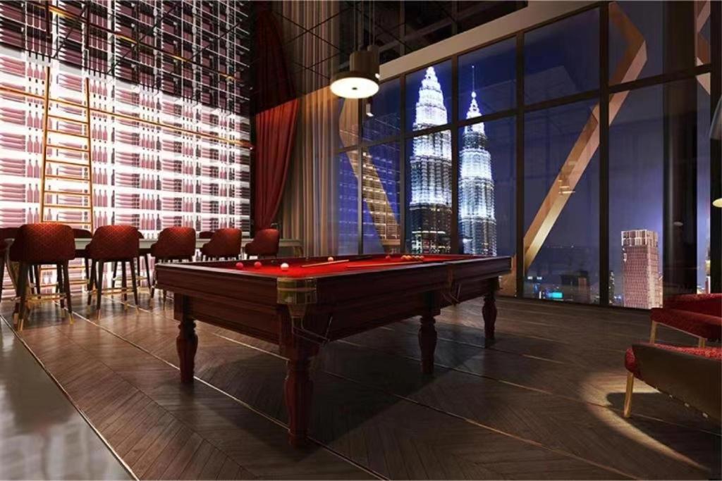 a room with a pool table in front of a large window at Borderless Swimming Pool - Invincible Twin Towers View - Free WiFi in Kampong Gombak Utara