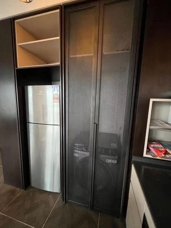 a black refrigerator and freezer in a kitchen at Borderless Swimming Pool - Invincible Twin Towers View - Free WiFi in Kampong Gombak Utara