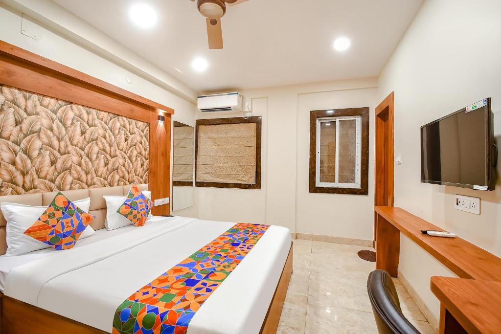 a bedroom with a large bed and a television at FabHotel Dream World Residency in Kolkata