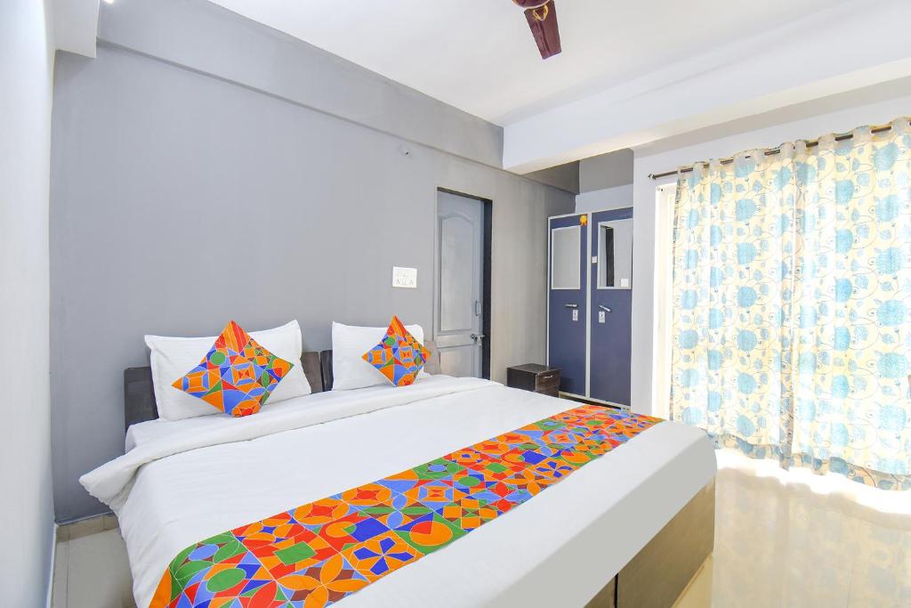 sypialnia z dużym łóżkiem i kolorowym kocem w obiekcie FabHotel Happy Stay In w mieście Hinjewadi