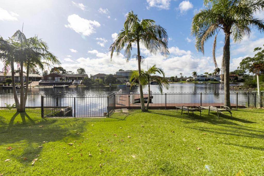 a park with palm trees and a body of water at Unbeatable Waterfront Location in Sussex Inlet