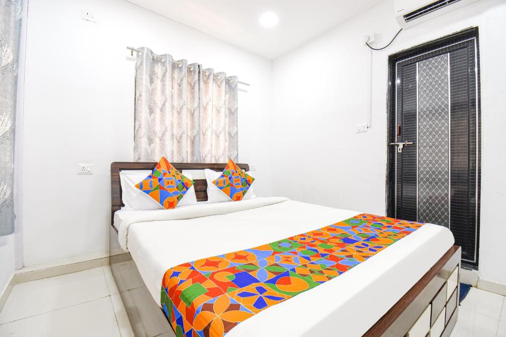 a bedroom with a bed with a colorful blanket at FabHotel Silver 7 Homes in Hinjewadi