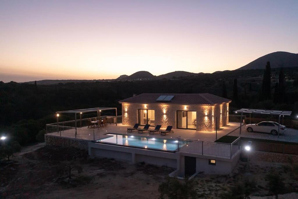 a villa with a pool and a car in front of it at Brand New: Kefalonia Stone Villas - Villa Trapezaki Retreat in Trapezaki
