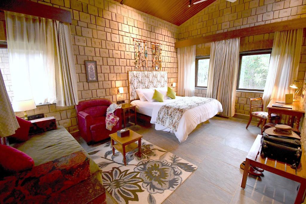 a bedroom with a bed and a couch in a room at Arbor Road Estate in Pāmalparti