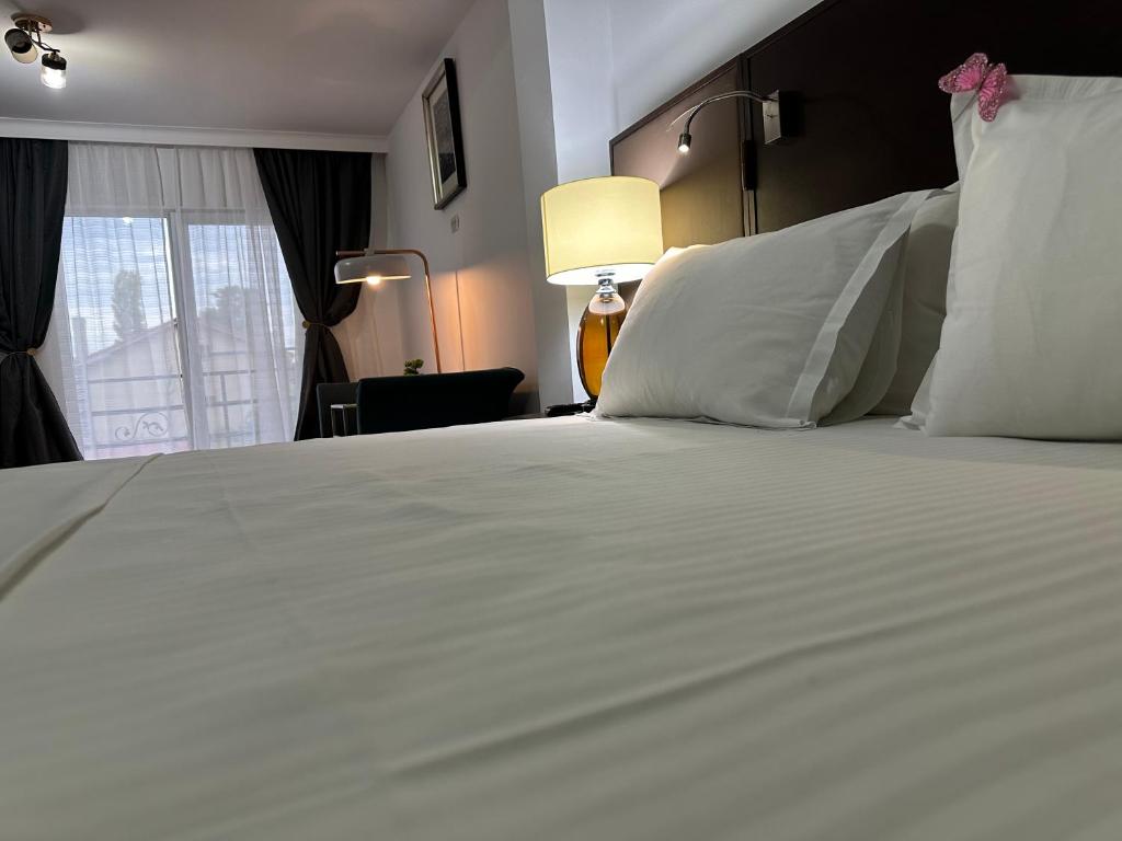 a large white bed in a room with a window at Vila Anda in Eforie Sud