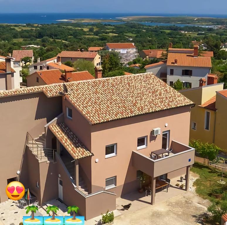 Cette villa offre une vue sur une maison avec un ballon de plage. dans l'établissement Apartmani B&B, à Ližnjan