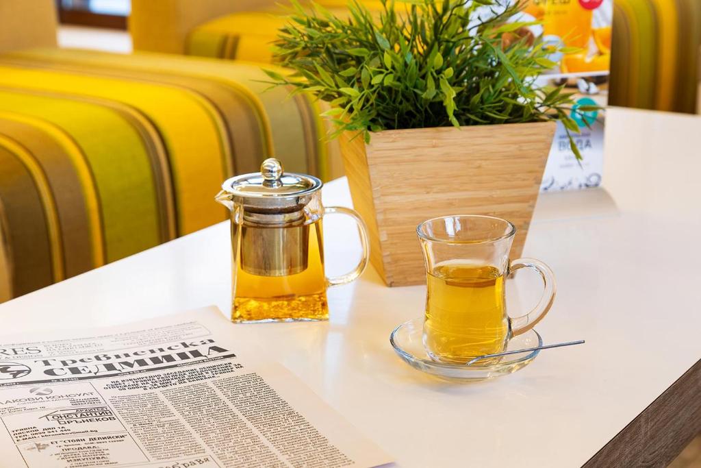 un pot de miel en verre assis sur une table avec un journal dans l'établissement Hotel Compliment, à Tryavna