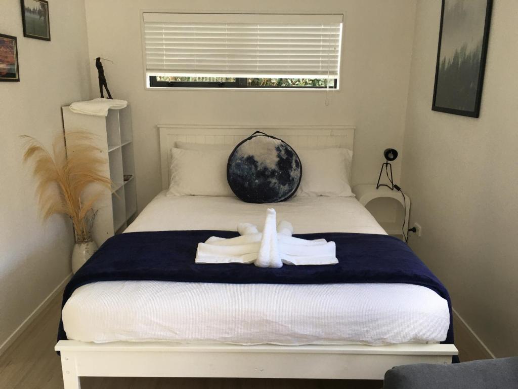 una camera da letto con un letto e un asciugamano sopra di West Auckland Delight Stay ad Auckland