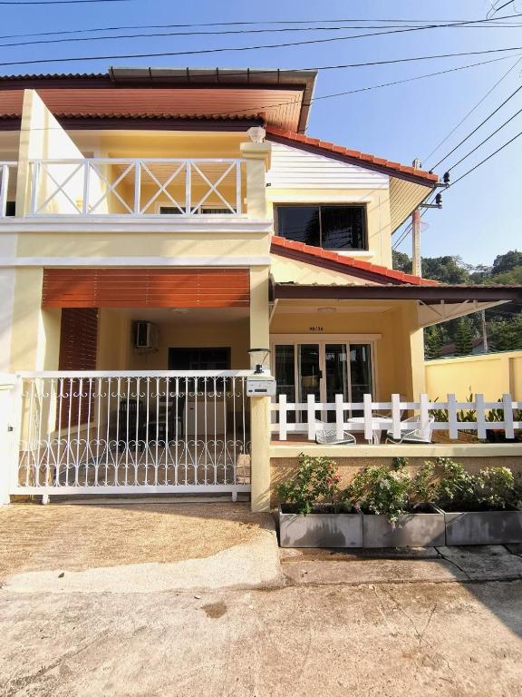 a house with a white fence in front of it at Kata beach townhouse in Kata Beach