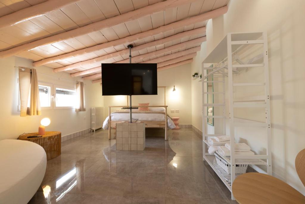 een slaapkamer met een bed en een tv aan de muur bij RaíZes 22 - Apartamento 6 in Puebla de Don Fadrique