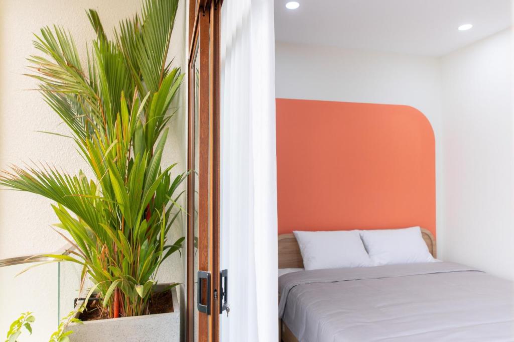 a bedroom with a bed and a plant at IN URBAN in Ho Chi Minh City