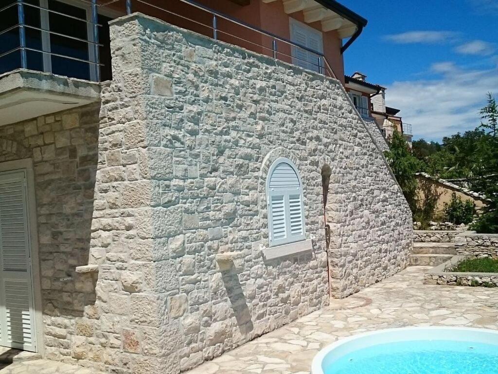 un edificio de piedra con una piscina frente a él en Vista Fantastico, en Rabac