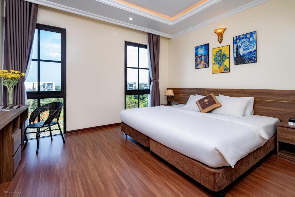 Schlafzimmer mit einem großen weißen Bett und Fenstern in der Unterkunft Passion Hotel HaLong in Hạ Long