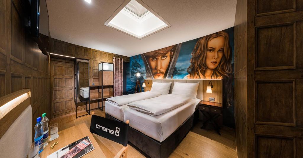 1 dormitorio con 1 cama extragrande y una pintura en Hotel Cinema 8, en Schöftland