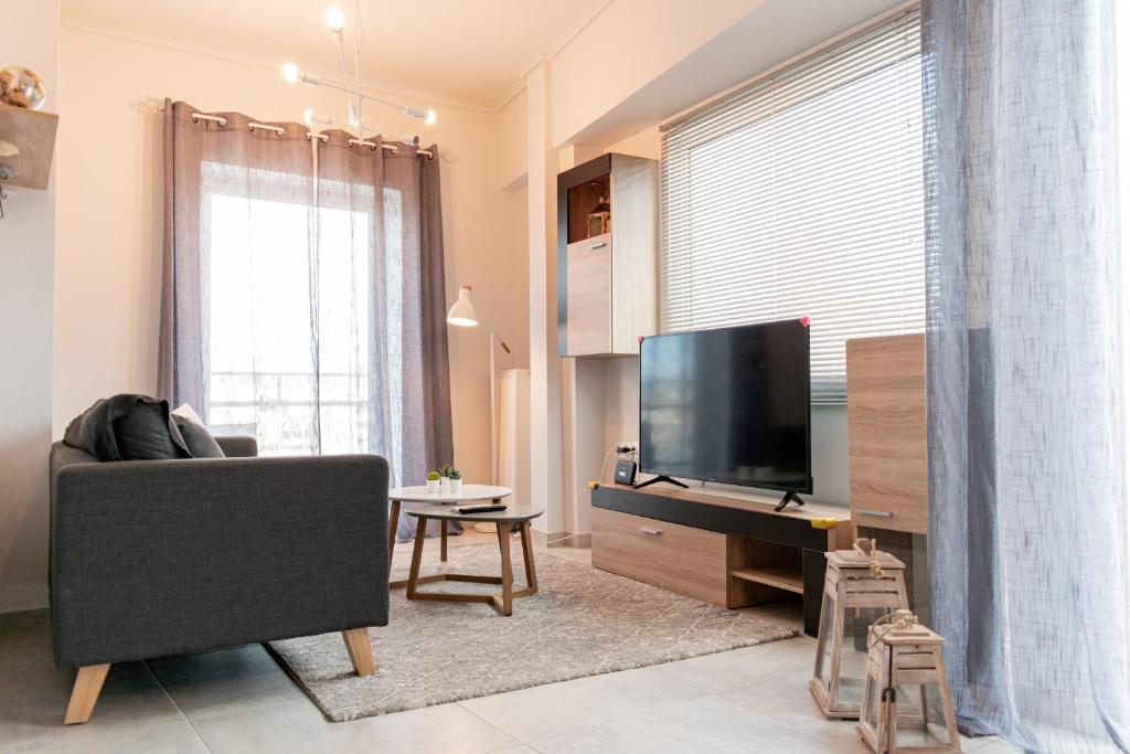 een woonkamer met een bank en een flatscreen-tv bij Gtrip Gazi Duplex Apartment - 33701 in Athene