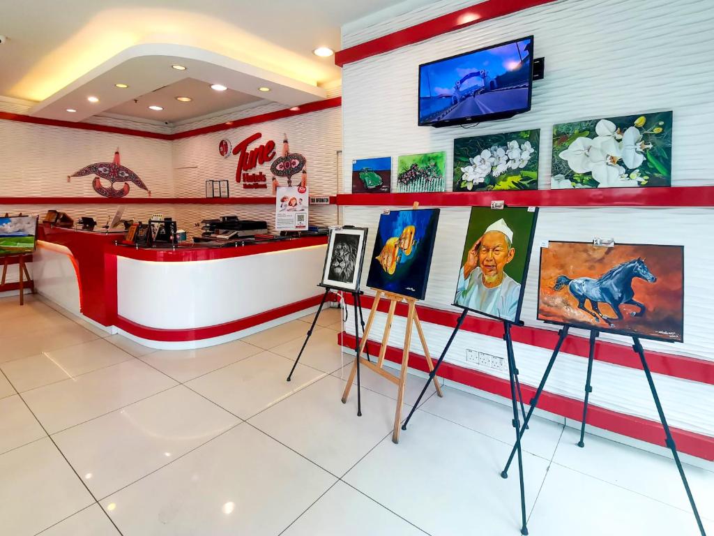 a restaurant with a counter with paintings on the wall at Tune Hotel – Kota Bharu City Centre in Kota Bharu