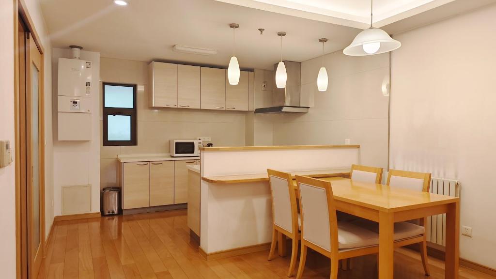 a kitchen and dining room with a table and chairs at Belgravia Serviced Residence Wuxi in Wuxi
