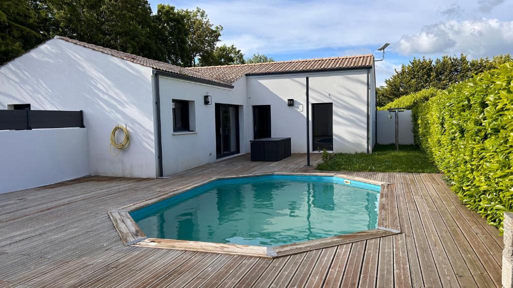 ein kleiner Pool vor einem weißen Haus in der Unterkunft Maison récente 3 chambres dont 1 suite parentale in Saint-Sauveur-dʼAunis