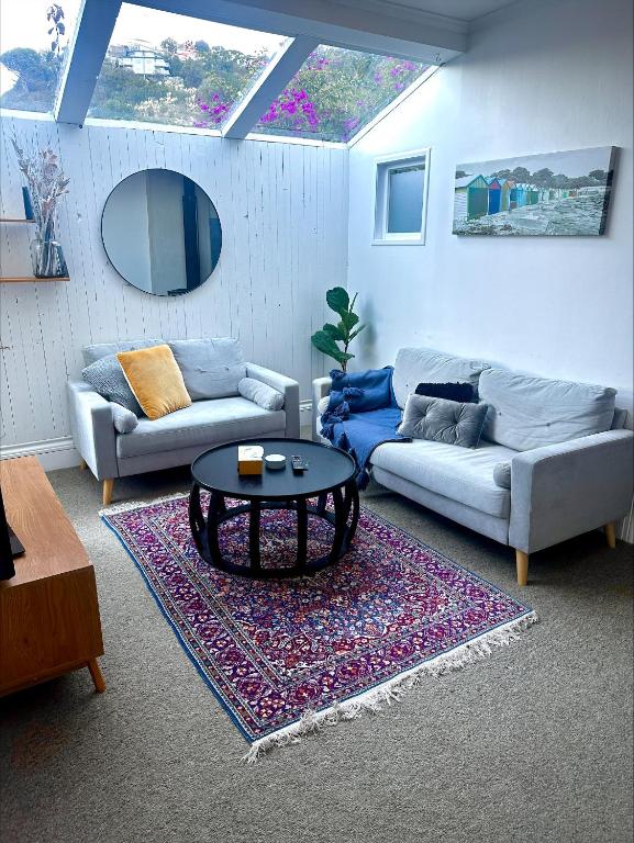 uma sala de estar com dois sofás e uma mesa de centro em Cosy Coastal Villa in Lyall Bay em Wellington