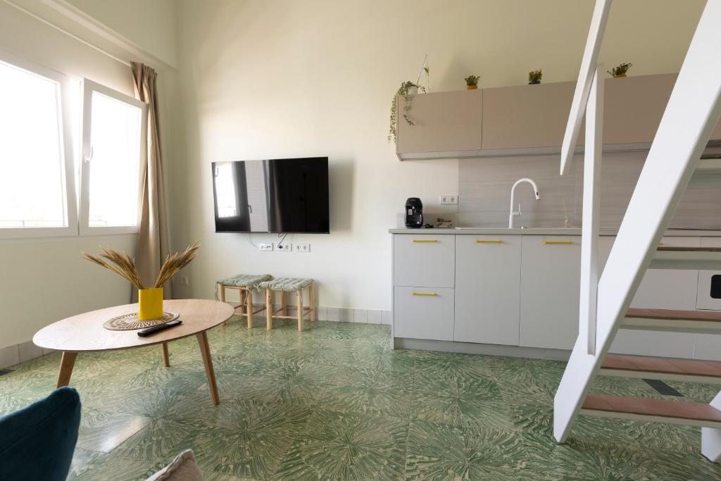 uma cozinha com armários brancos e uma mesa em RaíZes 22 - Apartamento 5 em Puebla de Don Fadrique