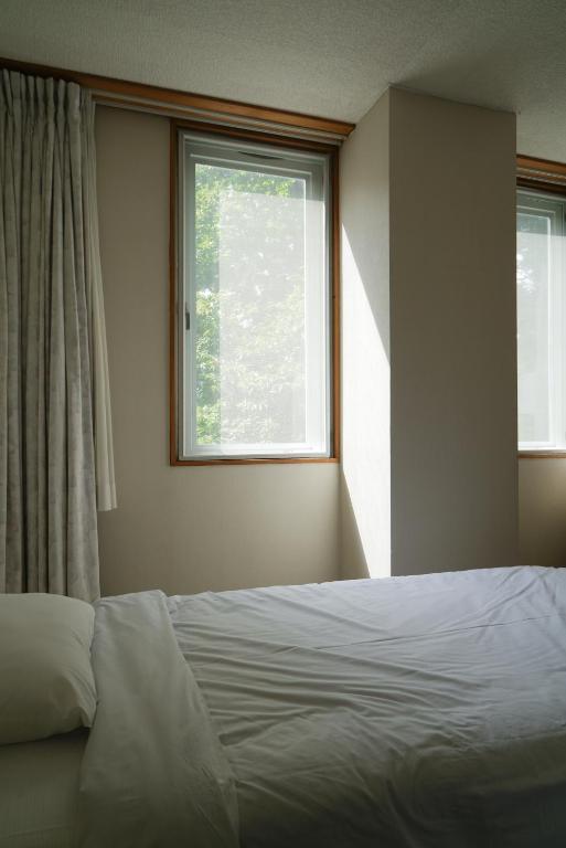 Postel nebo postele na pokoji v ubytování Hotel Bauhinia ホテルバウヒニア