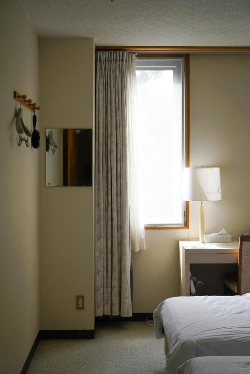 Postel nebo postele na pokoji v ubytování Hotel Bauhinia ホテルバウヒニア