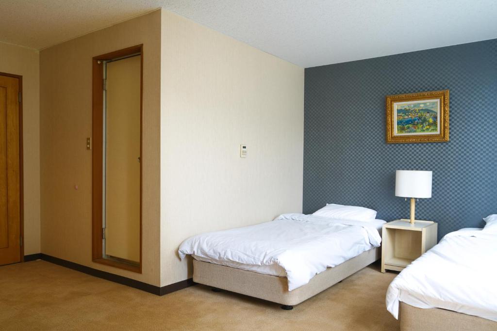Postel nebo postele na pokoji v ubytování Hotel Bauhinia ホテルバウヒニア