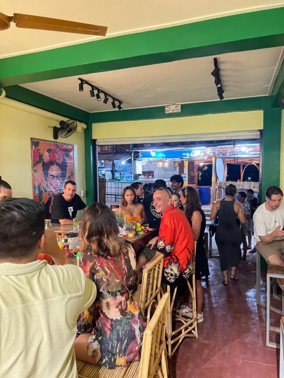 un gruppo di persone seduti a un tavolo in un ristorante di Frida Ka a El Nido