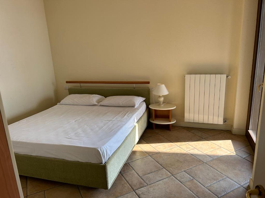 een kleine slaapkamer met een bed en een radiator bij Traum-Balkon mit Panoramablick und Pool am Lago Maggiore in Oggebbio