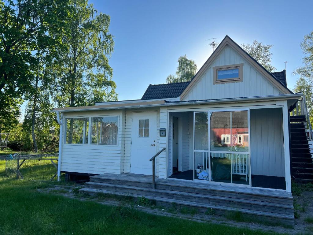 une petite maison blanche avec une véranda. dans l'établissement Villa Nybro, à Nybro