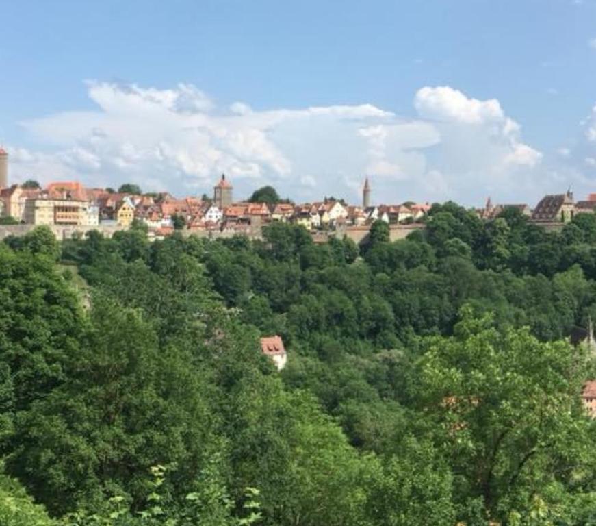 Blick auf eine Stadt von über den Bäumen in der Unterkunft Ferienhaus Kobolzeller Schlößchen a.d.Weinsteige in Rothenburg ob der Tauber