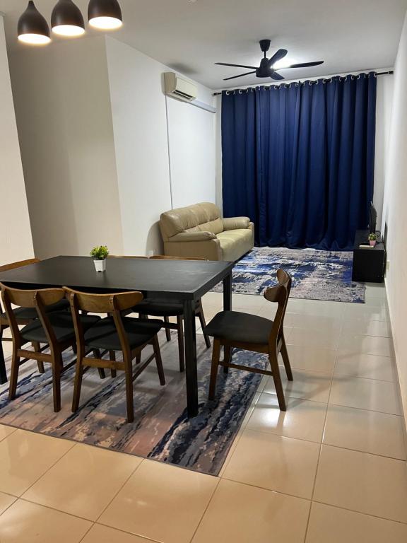 - un salon avec une table, des chaises et un canapé dans l'établissement Danau Homestay, à Bandar Puncak Alam