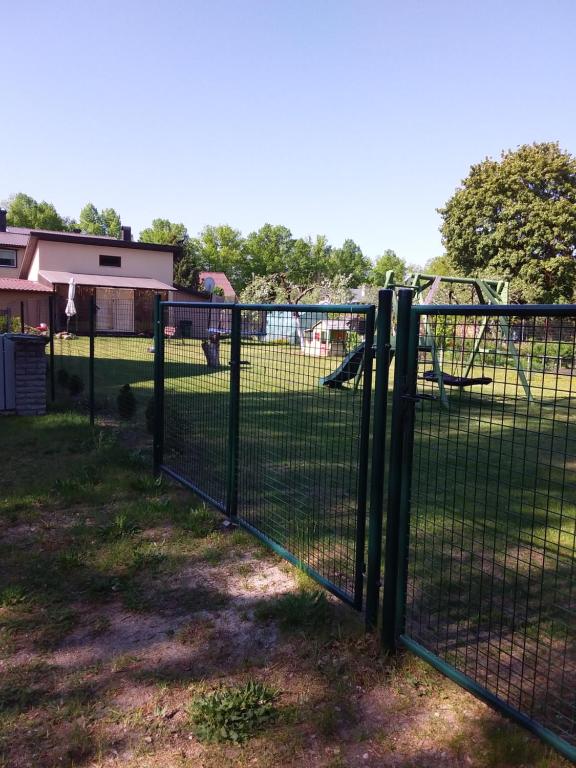 una valla en un parque con parque infantil en Домик для двоих en Pärnu