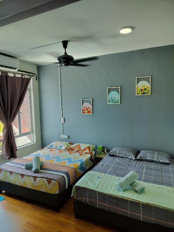 a bedroom with two beds and a ceiling fan at Idea Homestay 2 in Ipoh