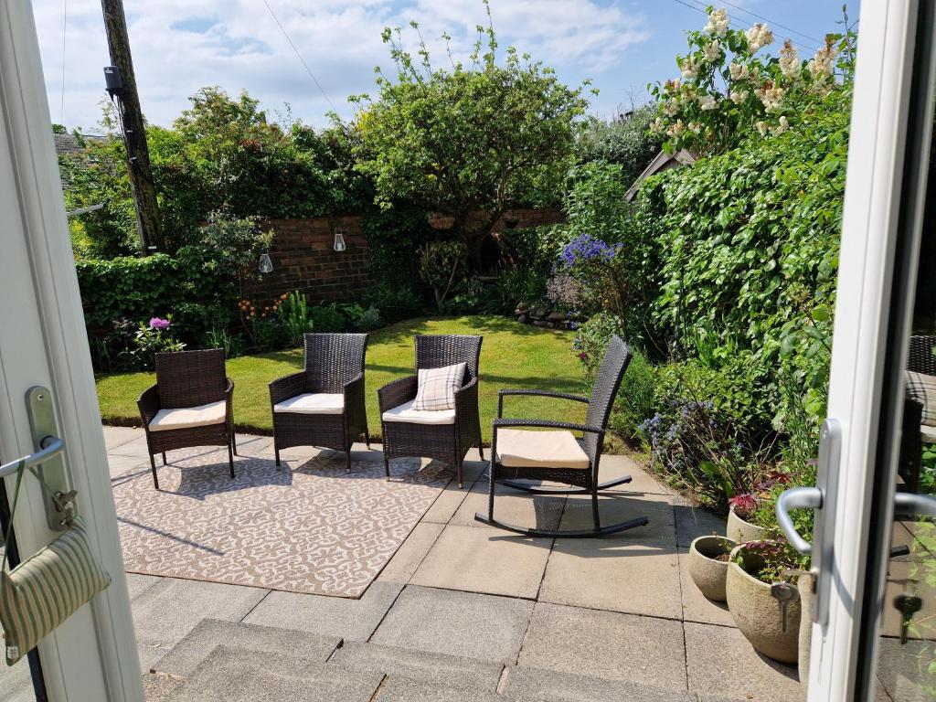 a group of chairs sitting on a patio at Troon Open golf - Private house with garden in central Prestwick in Prestwick