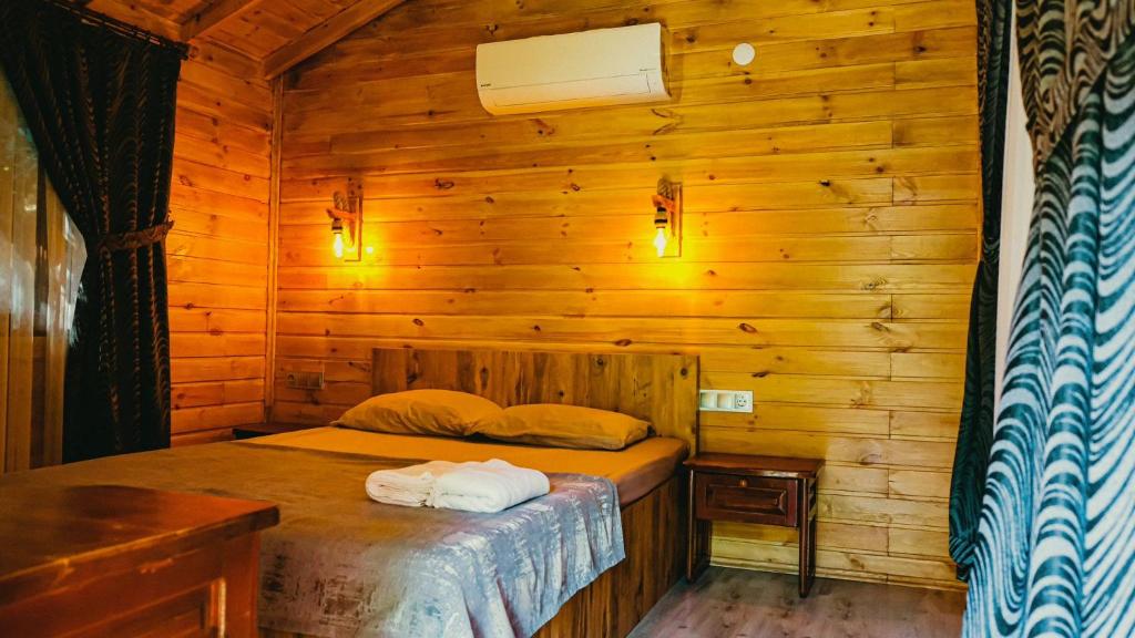 a bedroom with a bed in a wooden cabin at Sheriff, Olympos in Kumluca