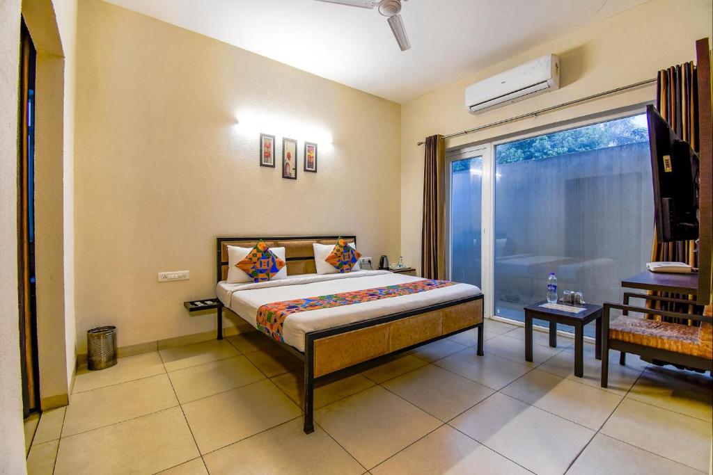 1 dormitorio con cama y ventana grande en FabHotel G-5 Villa en Ludhiana