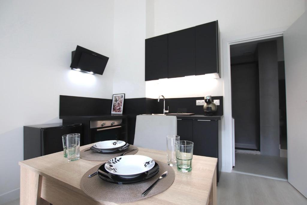 une cuisine avec une table avec des assiettes et des verres dessus dans l'établissement La Villa Riquet Menton, à Menton