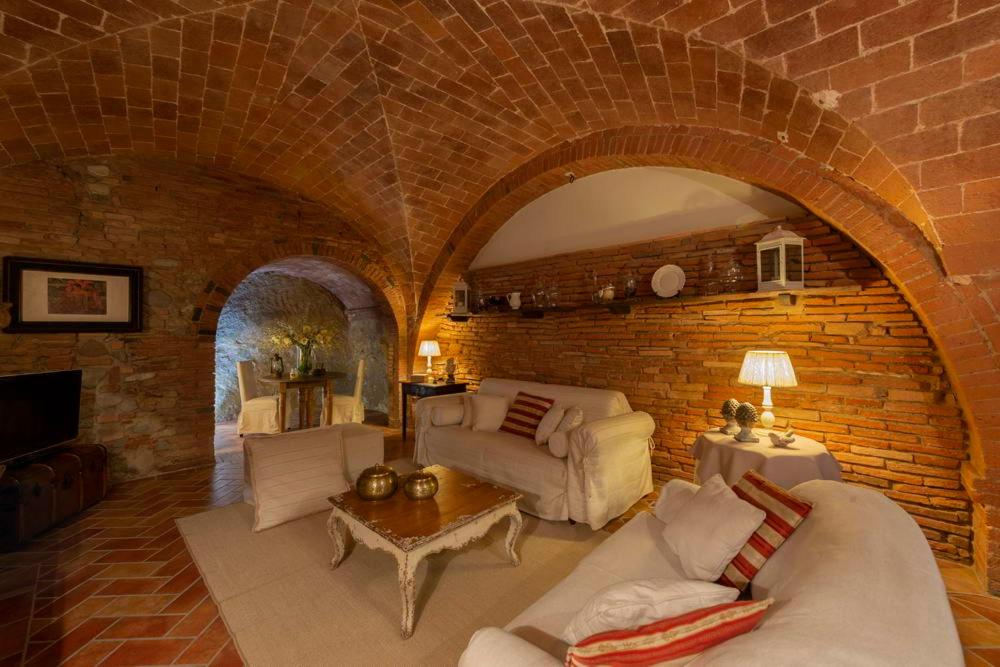un ampio soggiorno con muro di mattoni di La Casetta Di Borgo a Laiatico