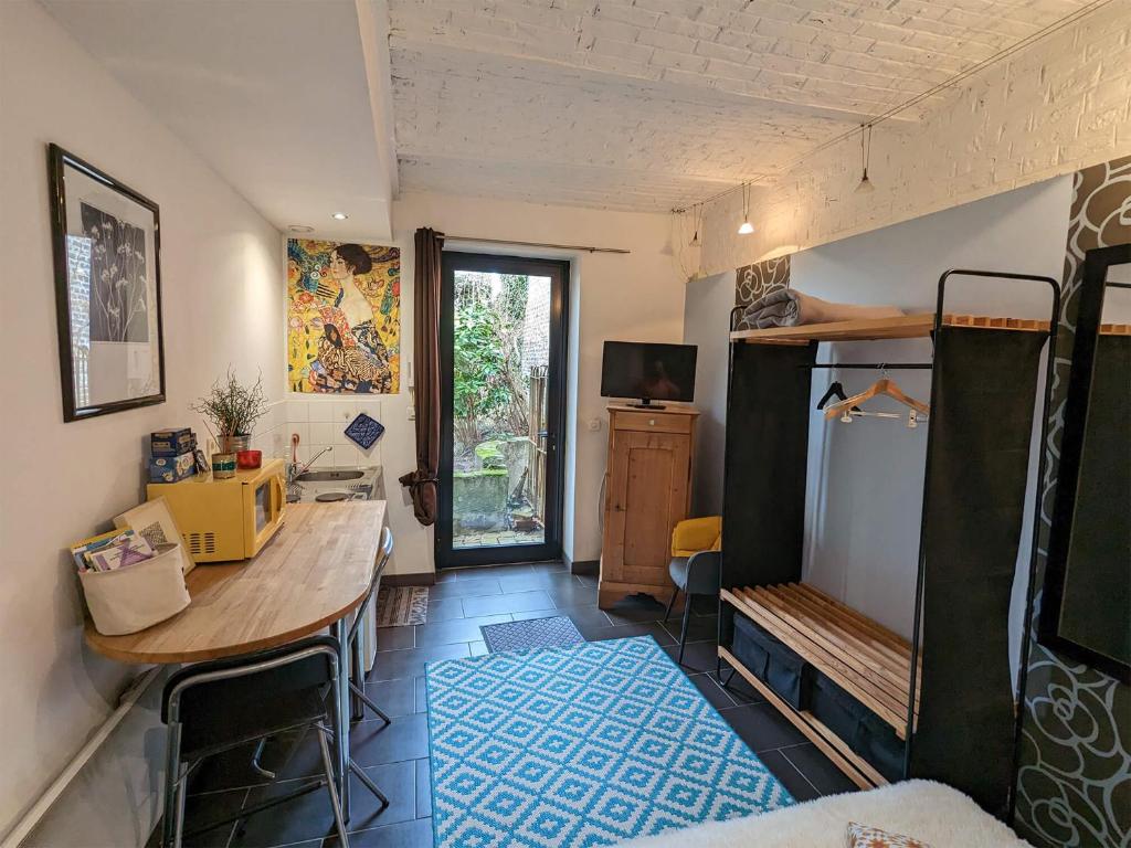 a room with a desk and a table in a room at La belle histoire à Roubaix in Roubaix