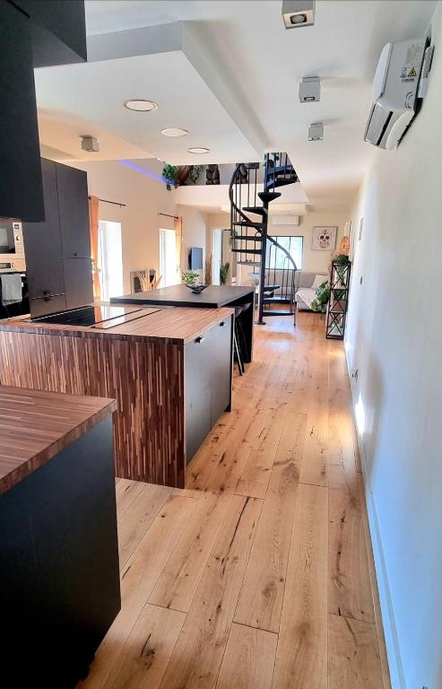 une cuisine ouverte avec parquet et un escalier dans l'établissement ! New Prestige Loft climatisé terrasse jacuzzi !, à Pont-à-Mousson