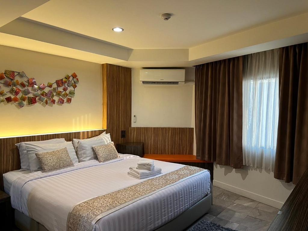 Habitación de hotel con cama y ventana en Dragon River Avenue en Phitsanulok