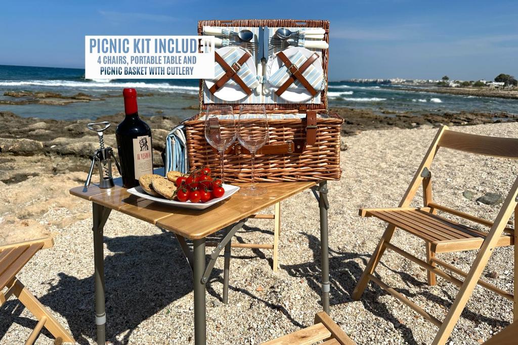 un tavolo con una bottiglia di vino e un cesto di frutta di Casa vacanza a 10 metri dal mare a Polignano a Mare