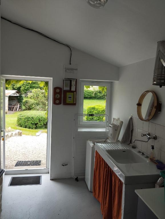 a bathroom with a sink and a mirror and a window at Maison au calme avec vue étang in Clessé