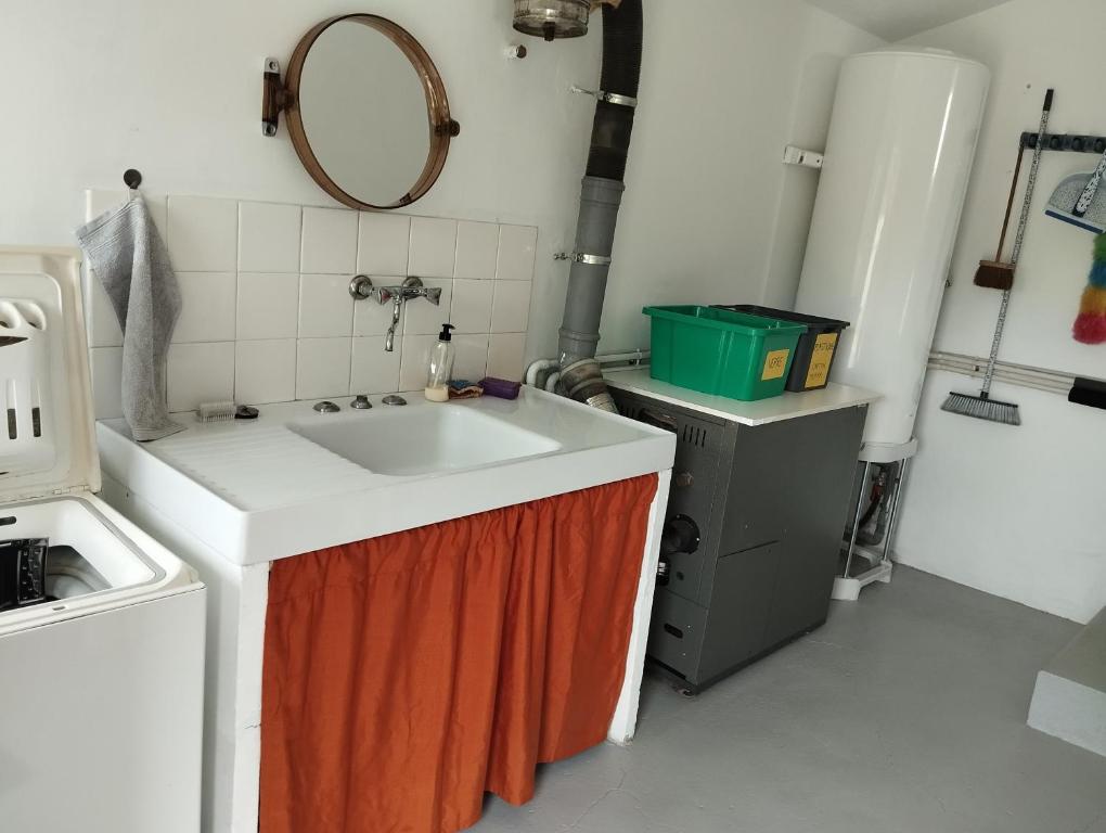 a kitchen with a sink and an orange towel under it at Maison au calme avec vue étang in Clessé
