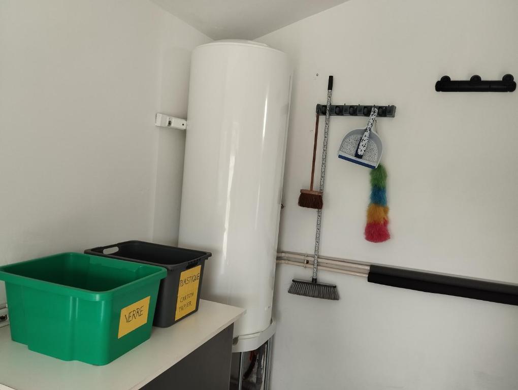 a room with a broom and a green box on a shelf at Maison au calme avec vue étang in Clessé