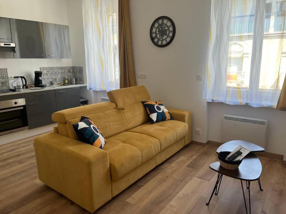 una sala de estar con un sofá y una mesa en L’industriel, en Montréjeau