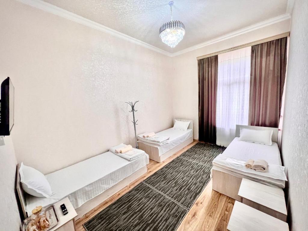 Cette chambre comprend 2 lits et une fenêtre. dans l'établissement MrShox Hostel, à Samarcande