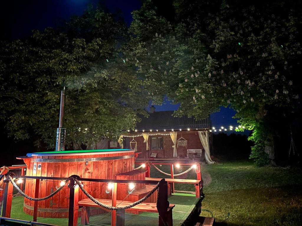 un escenario de madera con luces en el patio por la noche en Poleskie zacisze, domek na wyłączność, Wi - fi, Domek Bocian 